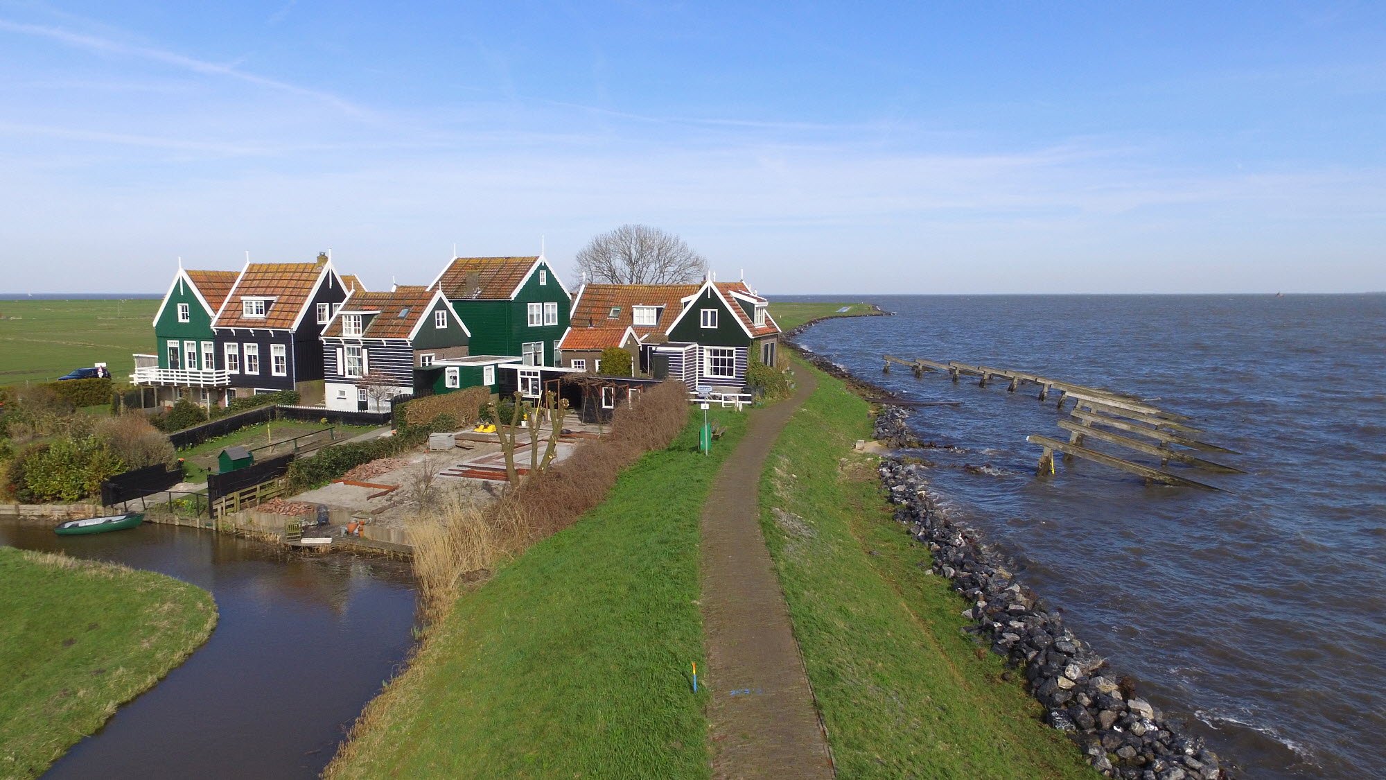 Groene houten huizen op marke. Zee op achtergrond